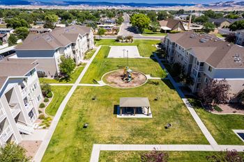 A large grassy area with a pavilion in the middle of apartment buildings.
